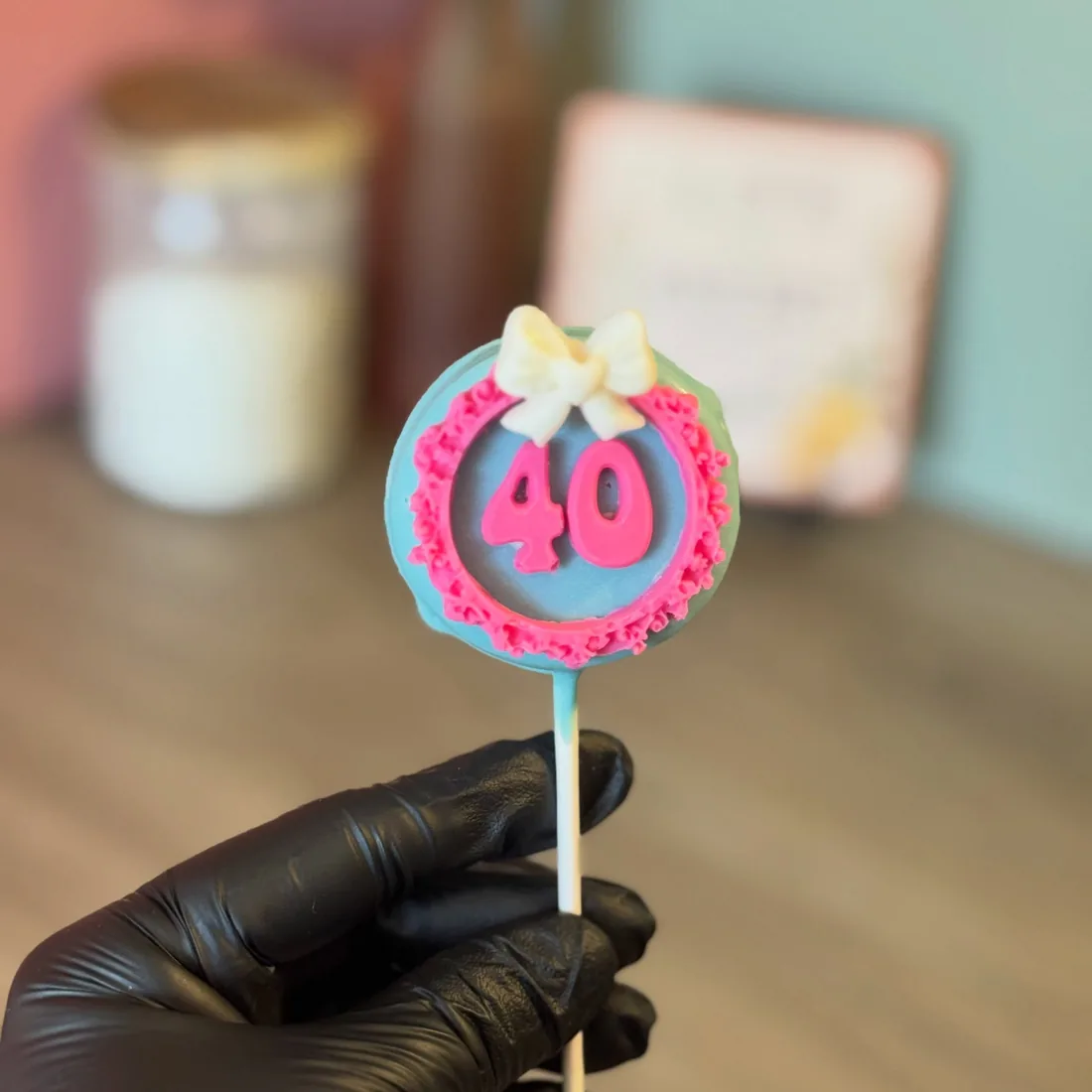 Teal and pink cake pop with a fondant 40 and a white bow