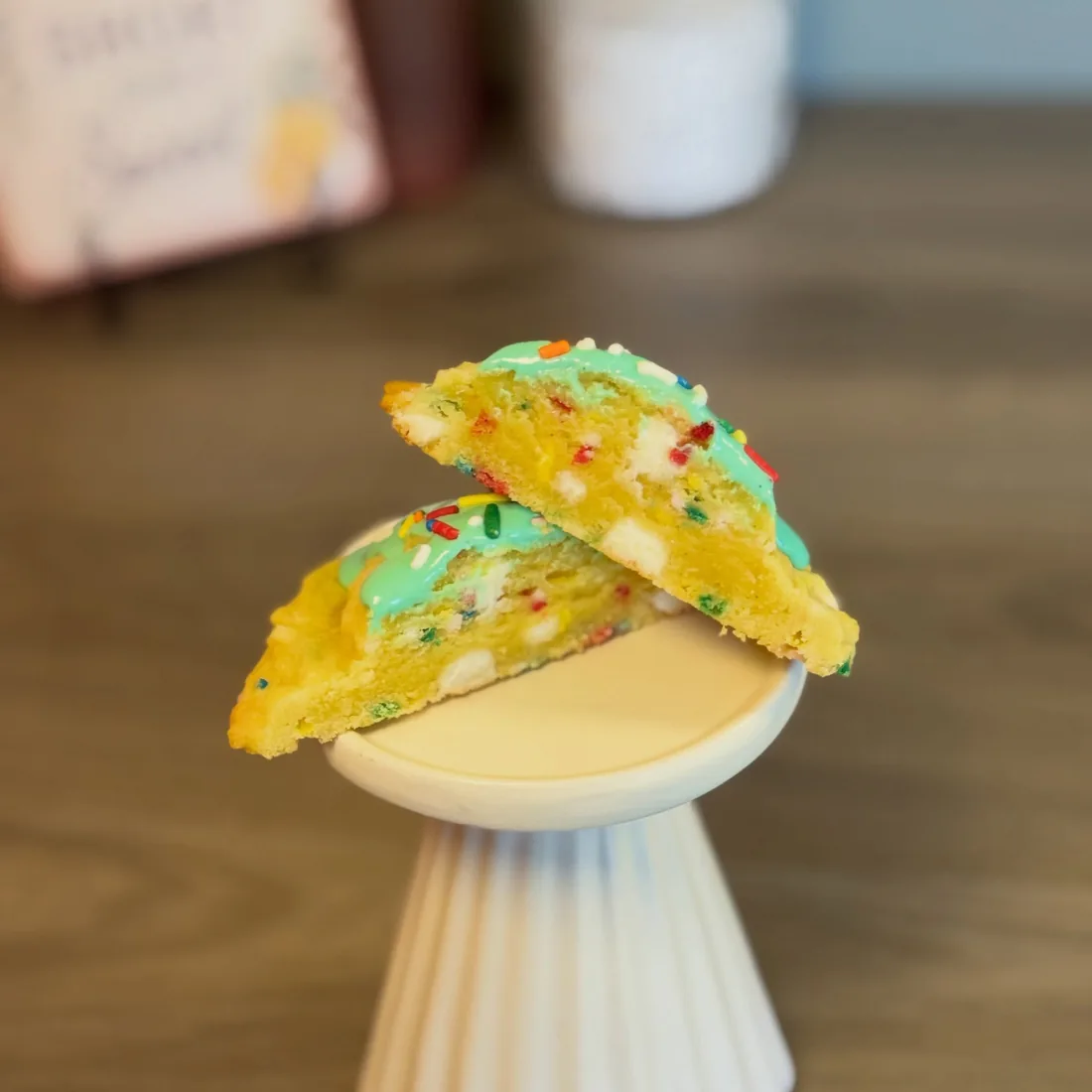 Birthday cake scoop cookie broken open to show the sprinkle-packed inside