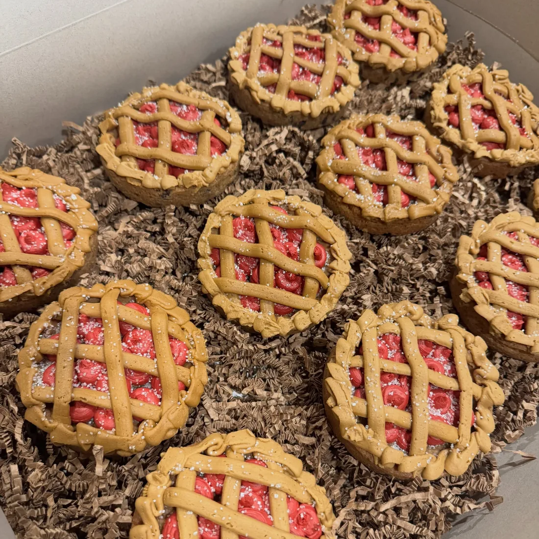 Tray of mini cherry cookie pies with piped buttercream lattices