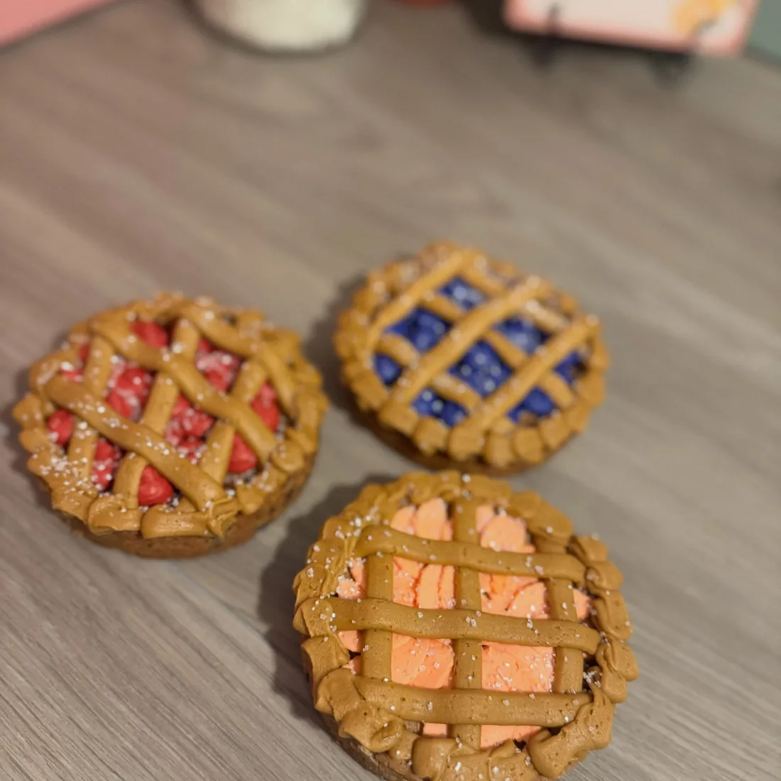 Three mini lattice cookie pies filled with cherry, blueberry and peach