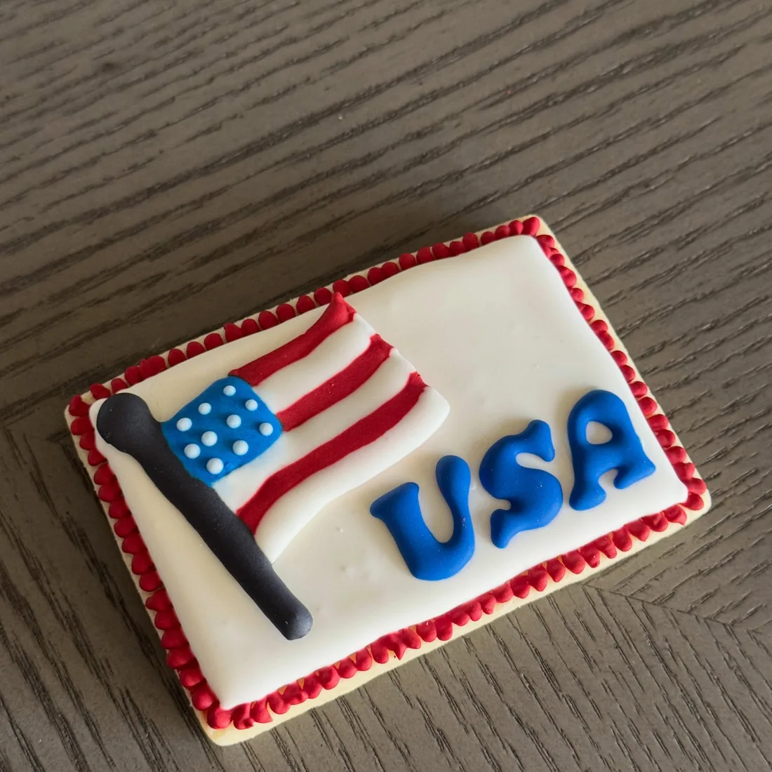Rectangle cookie decorated with an American flag and blue USA lettering