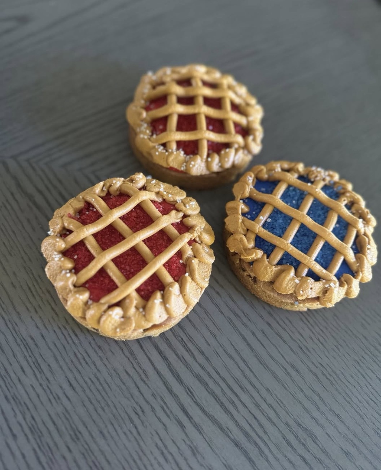 Chocolate chip cookies decorated to look like mini pies with buttercream frosting lattice in red and blue